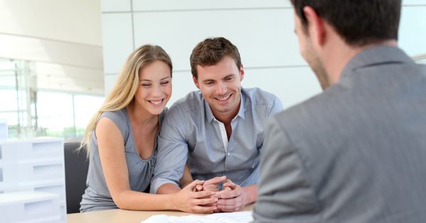 Couple in real-estate agency talking to construction planner