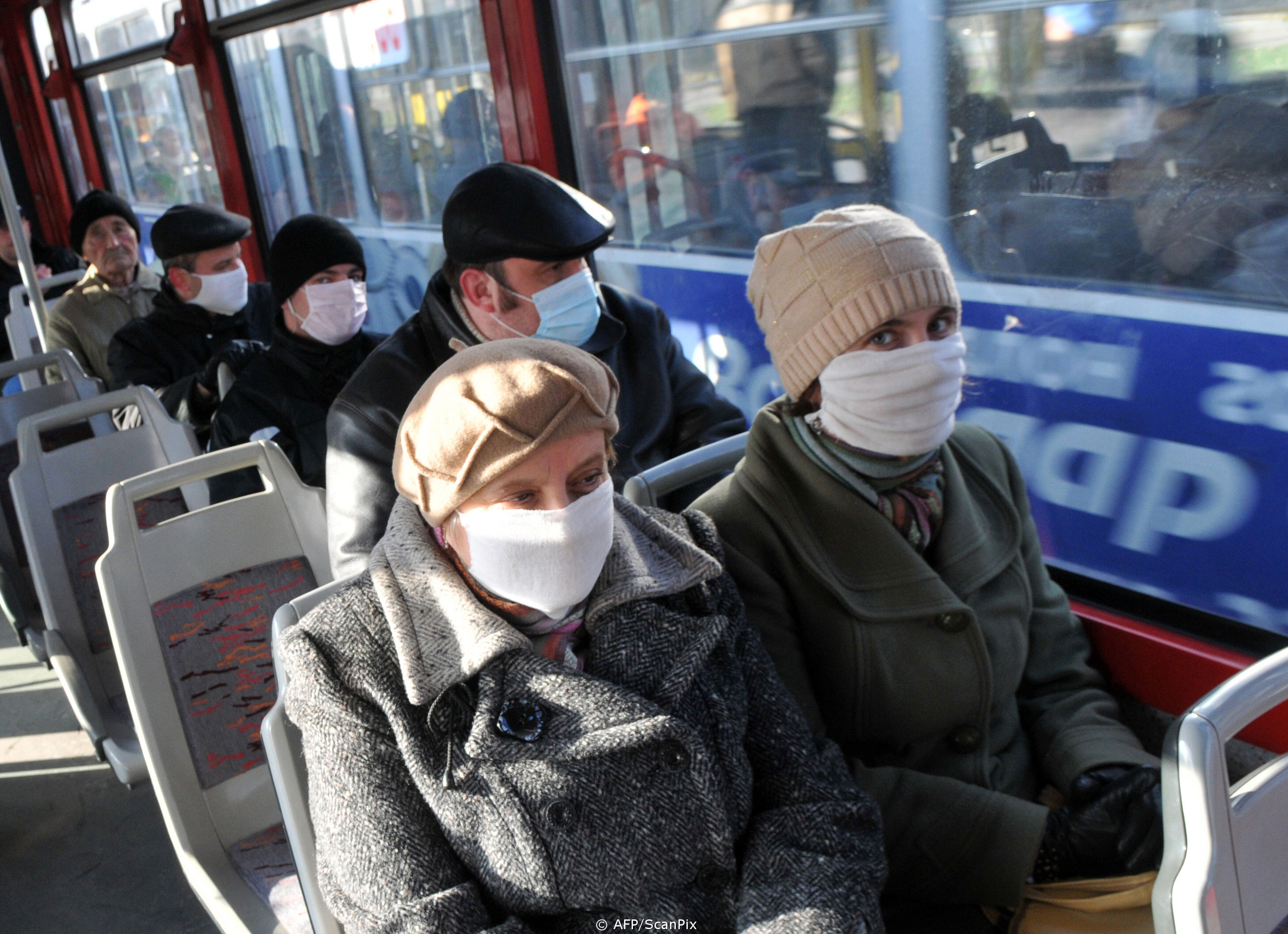 People wear protective masks as they ride the tram in the western Ukrainian city of Lviv on November 3, 2009. The Ukrainian health ministry raised on November 2 the death toll from the flu and respiratory problems to 67 on November 2, without detailing when the deaths took place or explaining the jump in the toll. AFP PHOTO/YURIY DYACHYSHYN