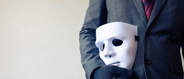 Business man carrying white mask to his body indicating Business fraud and faking business partnership