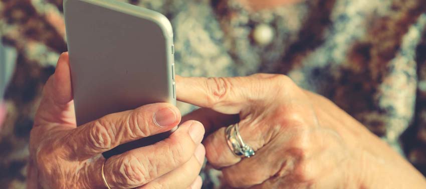 Hands of an elderly woman holding a mobile phone